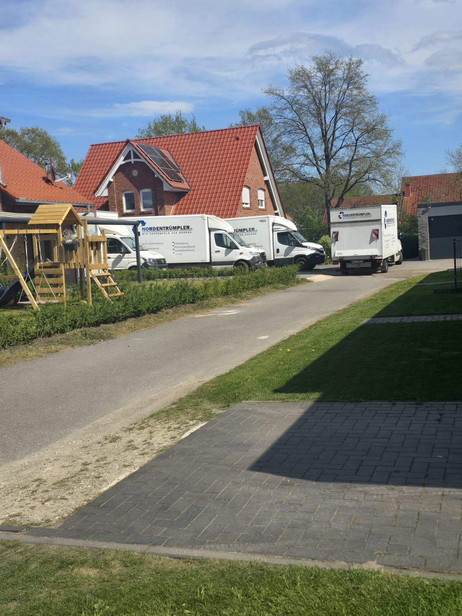 Nordentrümpler-Konvoi mit zwei Fahrzeugen vor einem Einfamilienhaus
