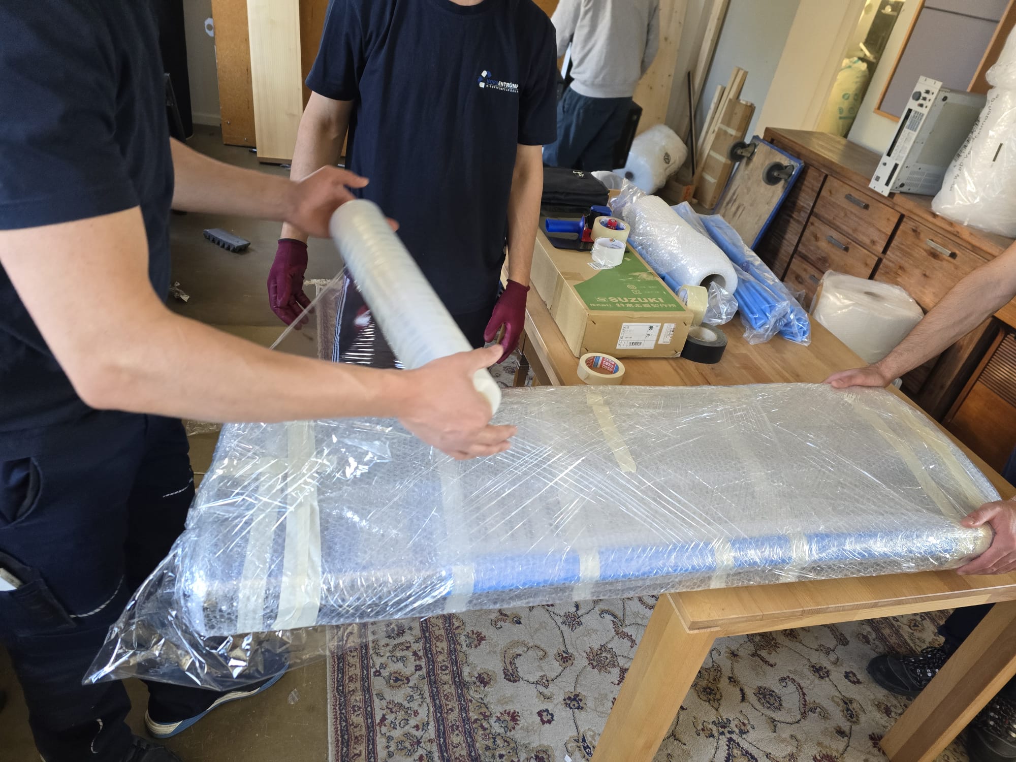 Nordentrümpler-Team verpackt ein Möbelstück fachgerecht für den Transport