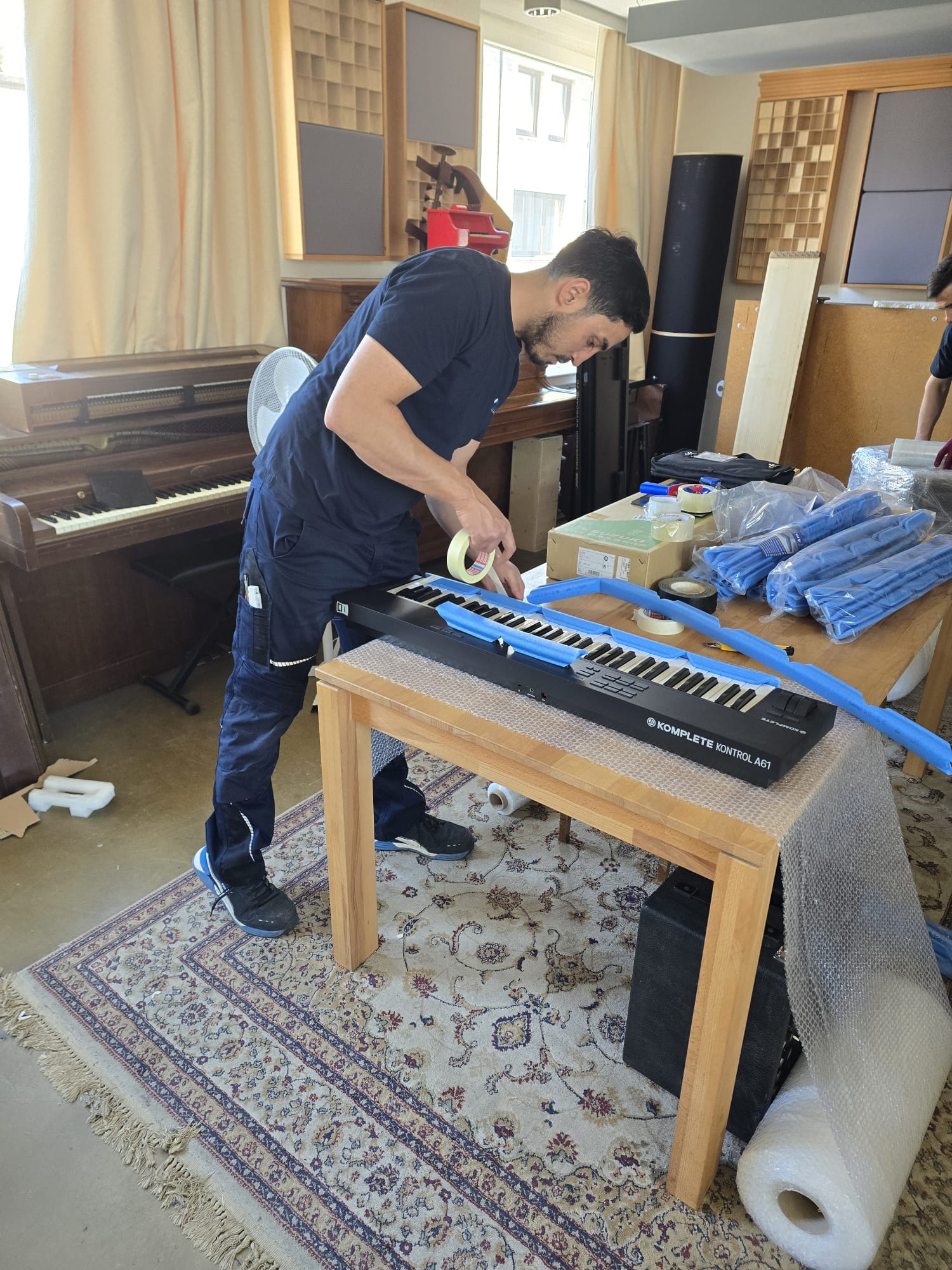 Mitarbeiter verpackt ein Klavier in einem Hamburger Altbau